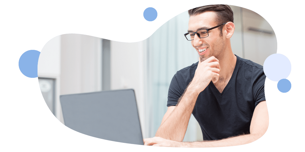 Immagine di un ragazzo sorridente che guarda lo schermo del suo computer portatile