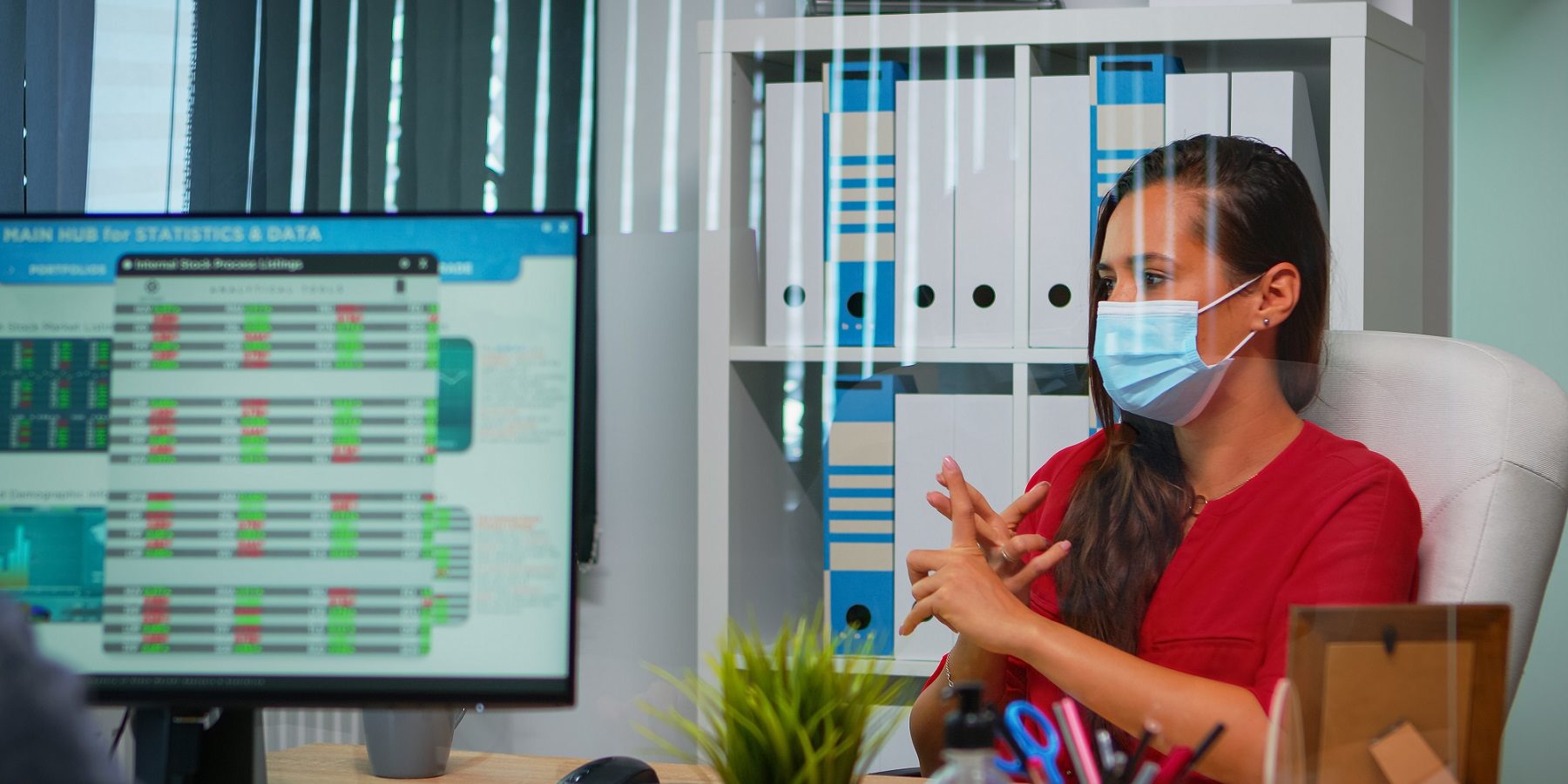 Operatore con mascherina in ufficio davanti a un computer