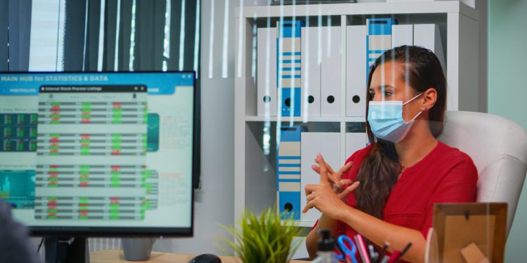 Operatore con mascherina in ufficio davanti a un computer