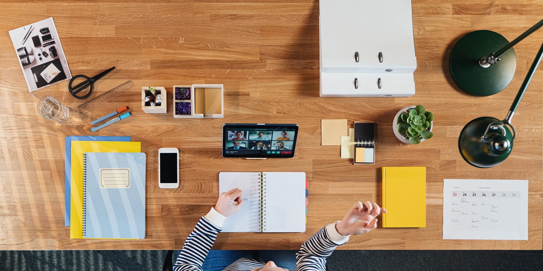 Veduta dall’alto di una operatrice al lavoro con videochiamate Operatrice vista dall'alto al lavoro con videochiamate e messaggistica immediata